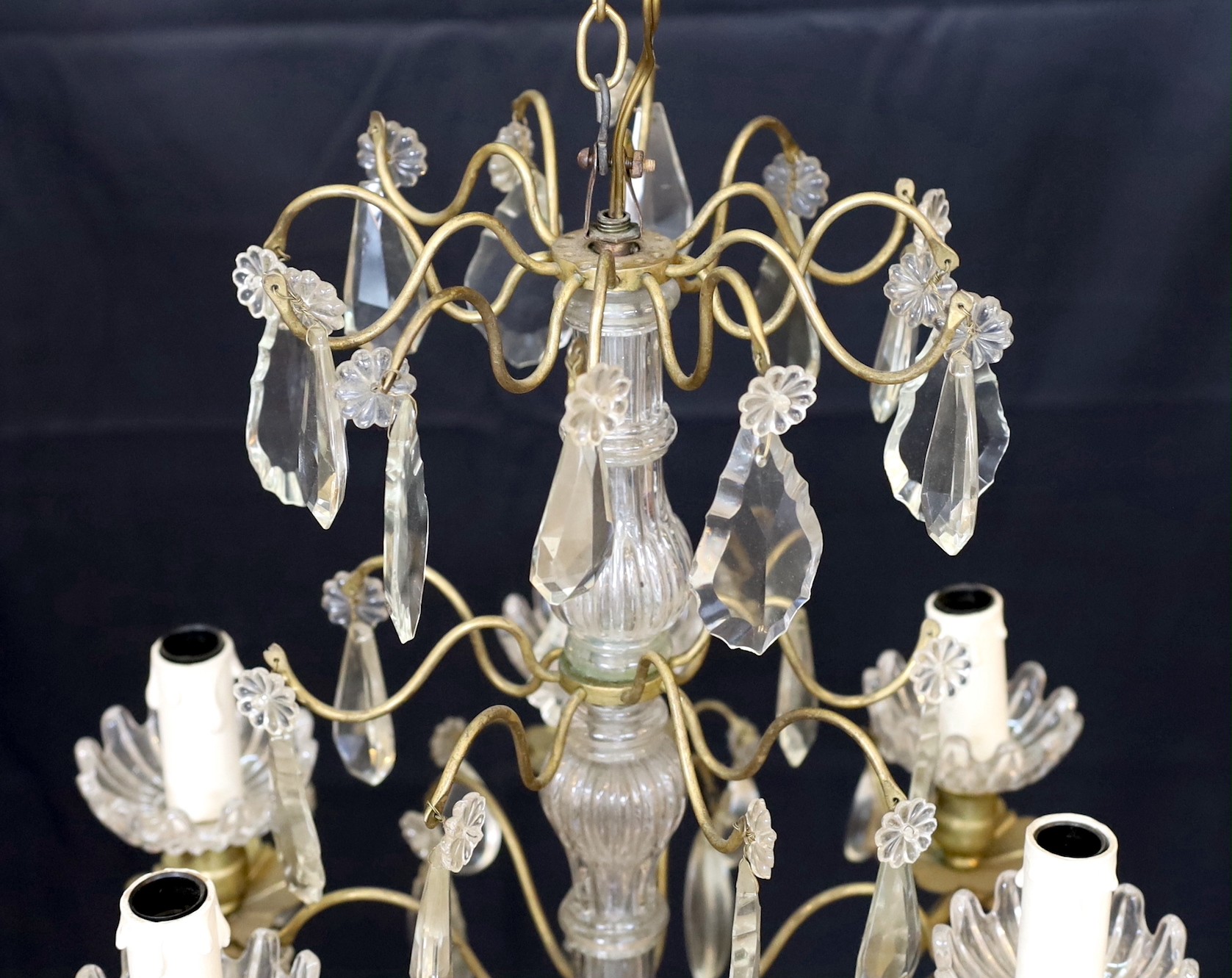 An early 20th century French bronze and cut glass six light chandelier hung with tear and lozenge shaped drops, drop 50cm. width 35cm